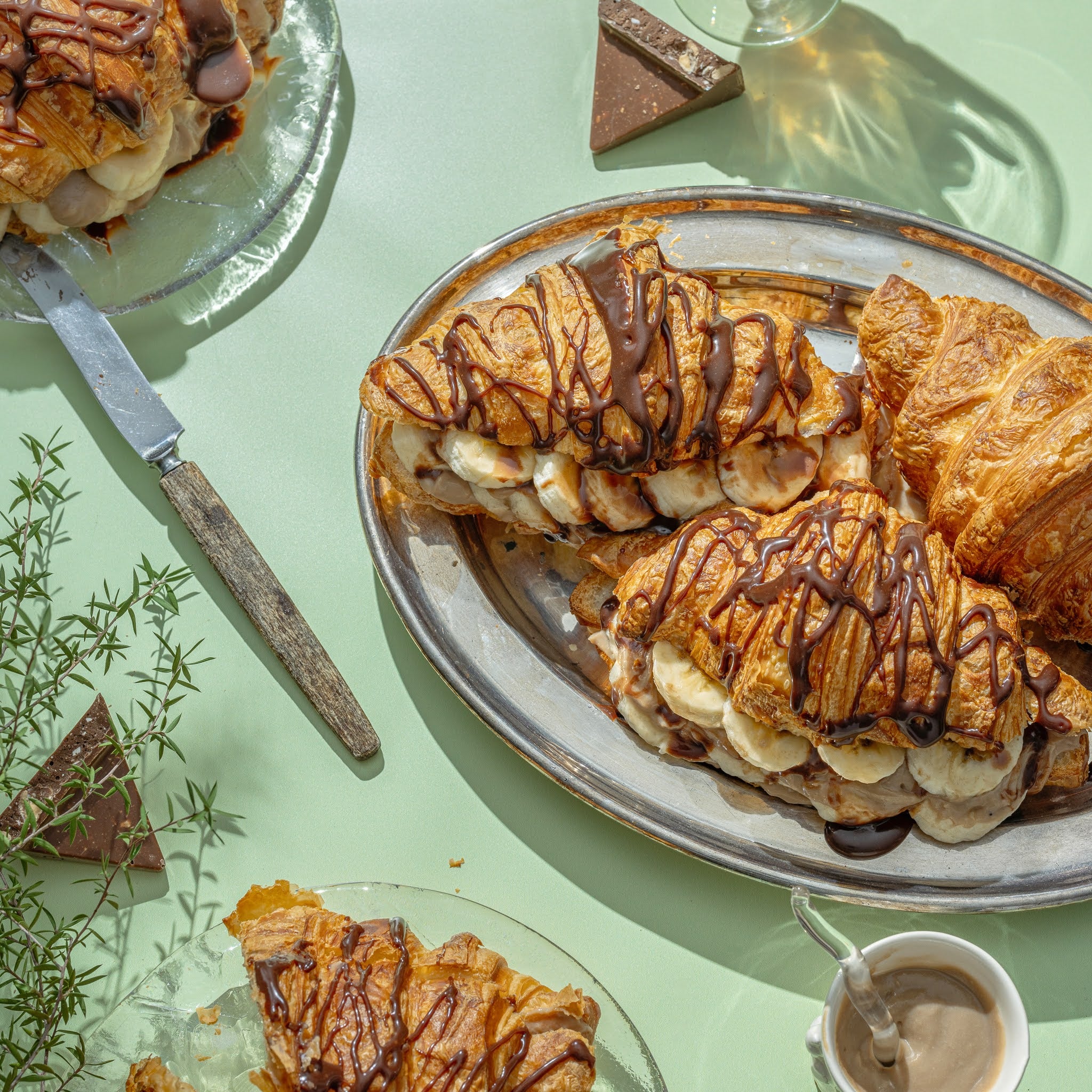 Croissants turned into dessert with chocolate banana caramel on a green table setting